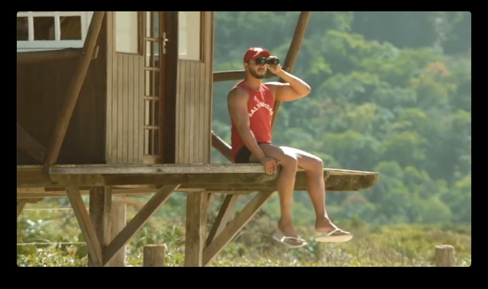 a man sitting on top of a wooden structure