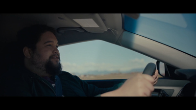 a man sitting in a car holding a steering wheel