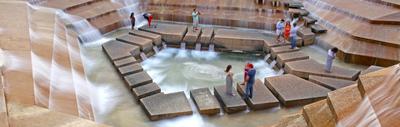 a group of people standing around a fountain