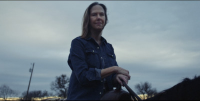 a woman riding on the back of a brown horse