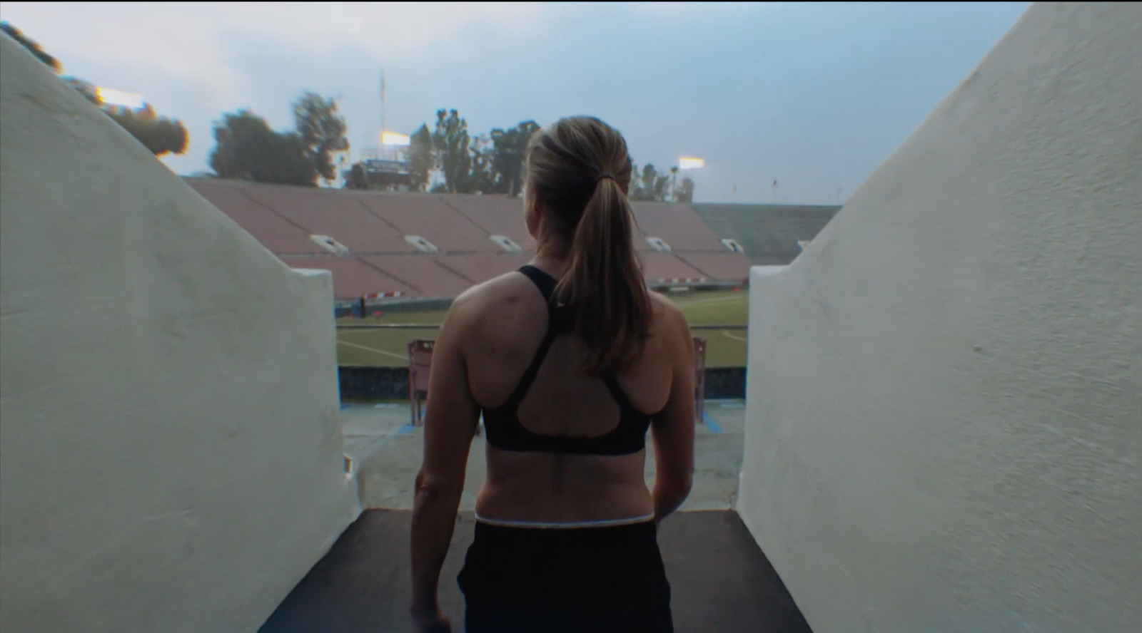 a woman in a sports bra top walking up a ramp