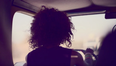 a woman with curly hair sitting in a car