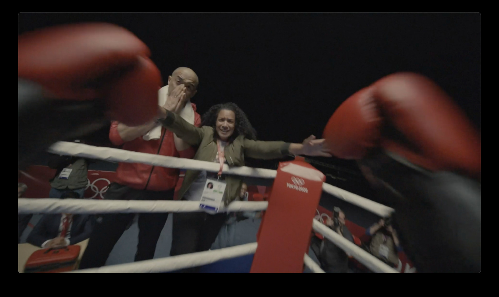 a woman standing next to a man in a boxing ring