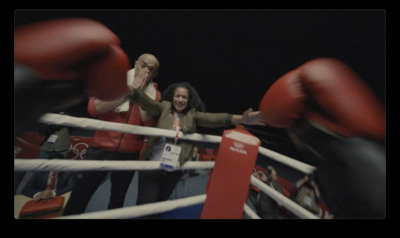 a woman standing next to a man in a boxing ring