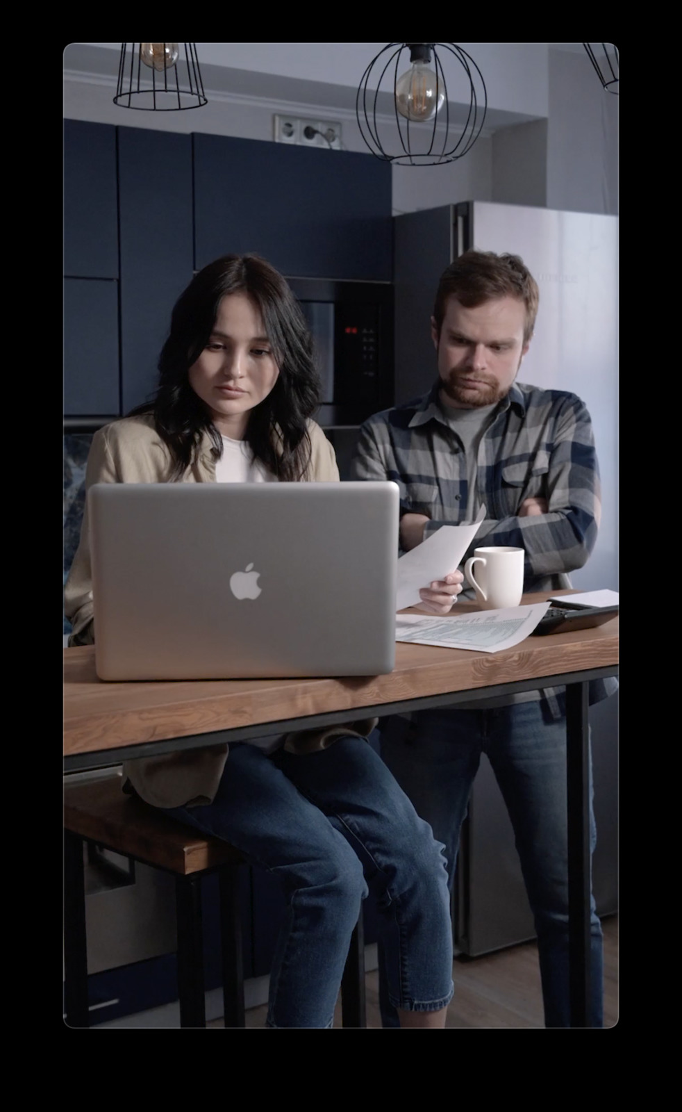 a man and a woman sitting at a table with a laptop