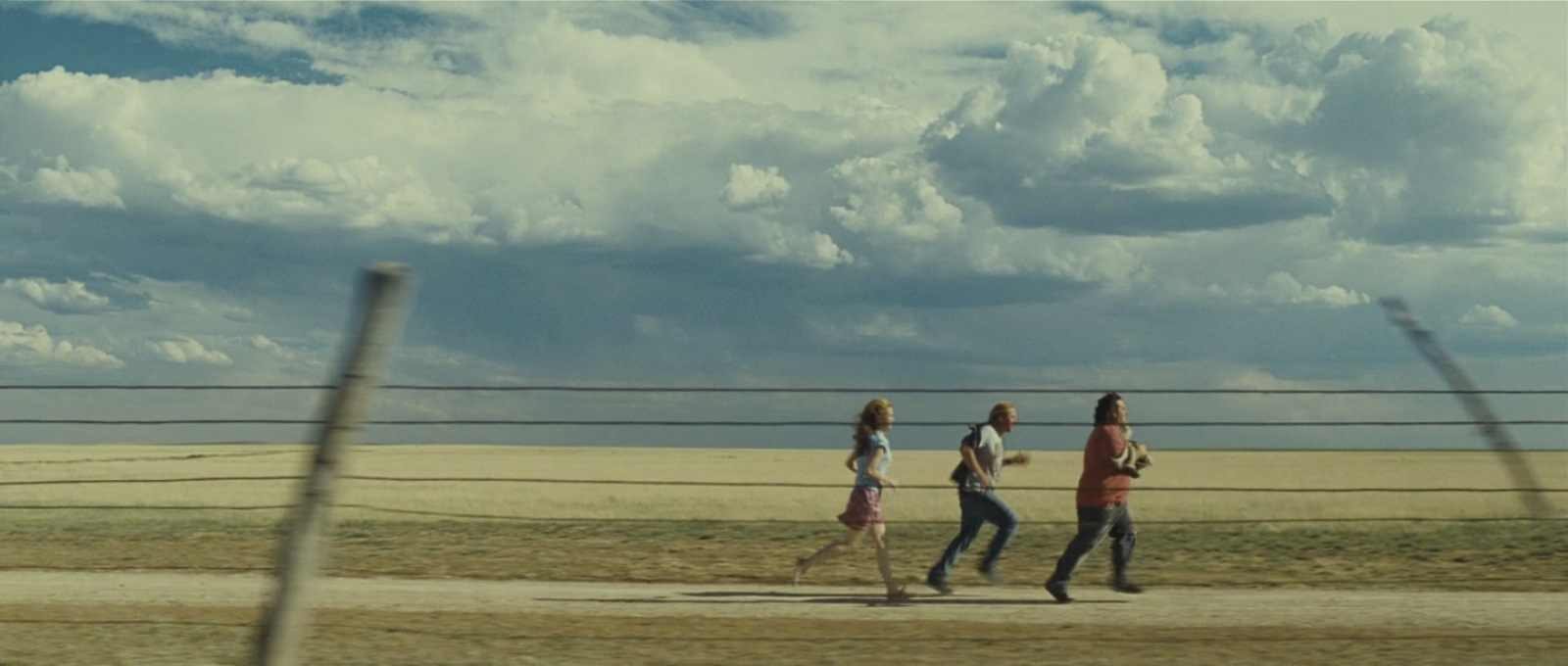 a group of people walking down a dirt road