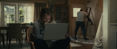 a woman sitting in a chair using a laptop computer