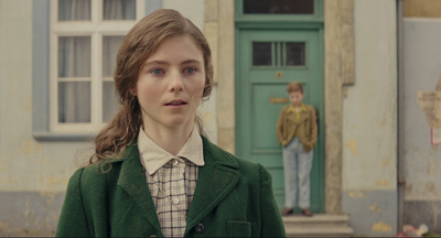 a woman standing in front of a green door