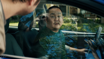 a man sitting in a car talking to another man