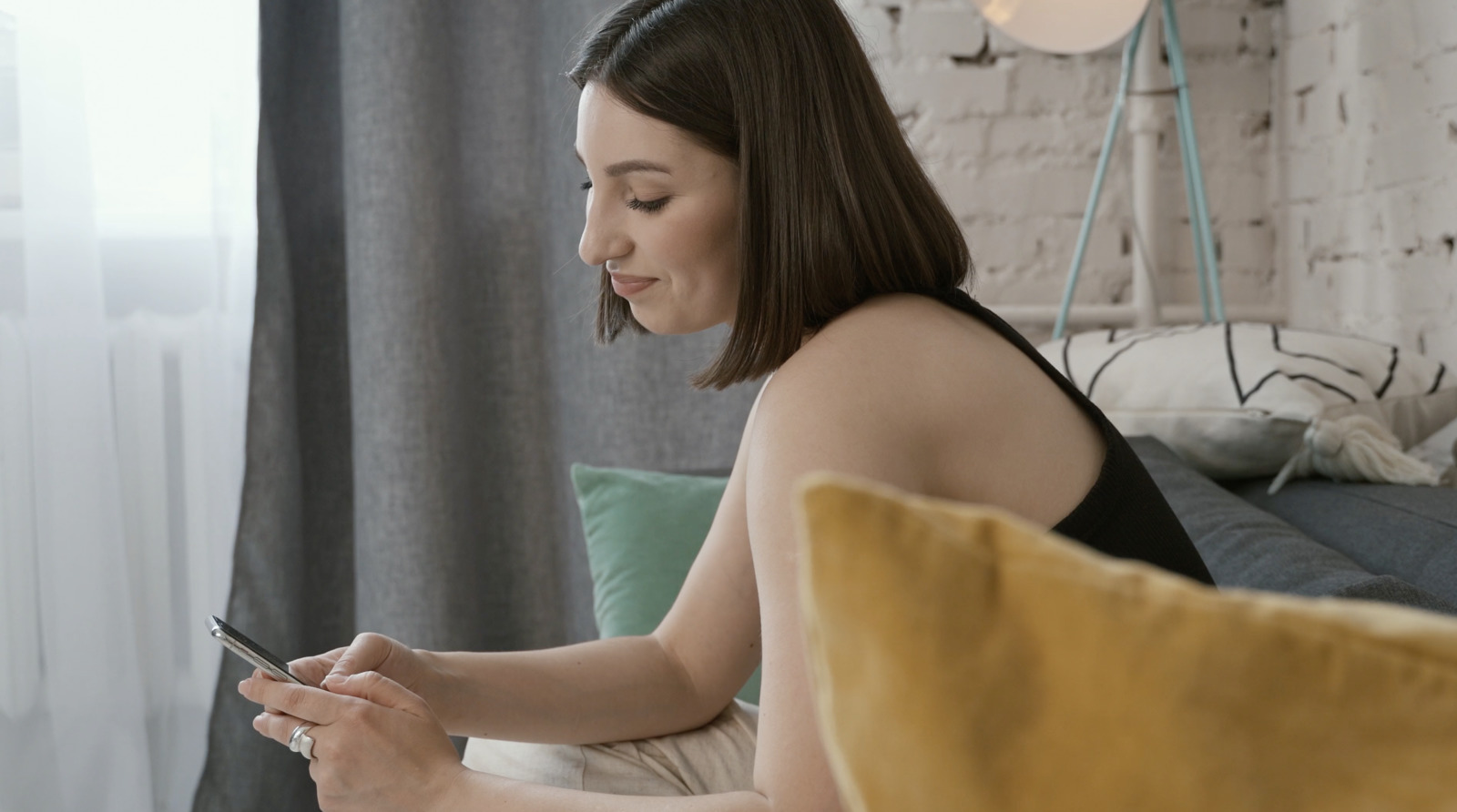 a woman sitting on a couch looking at her cell phone