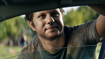 a man sitting in a car looking out the window