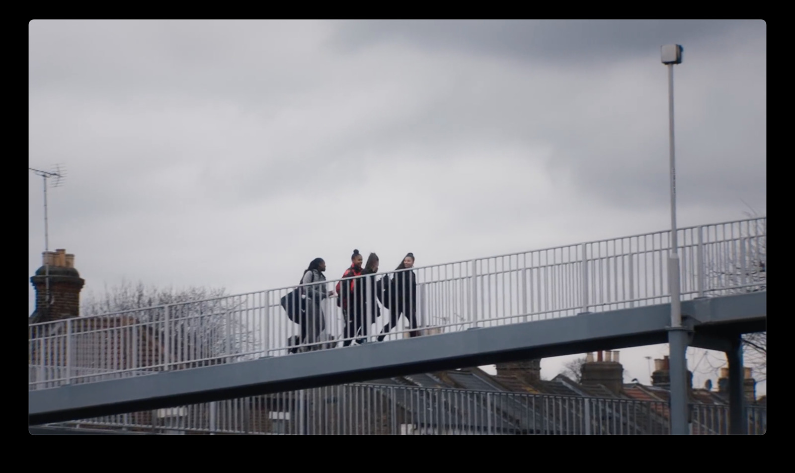 a group of people walking across a bridge