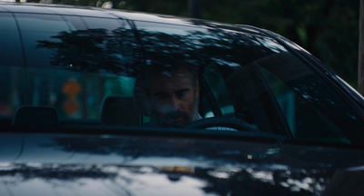 a man driving a car in the rain