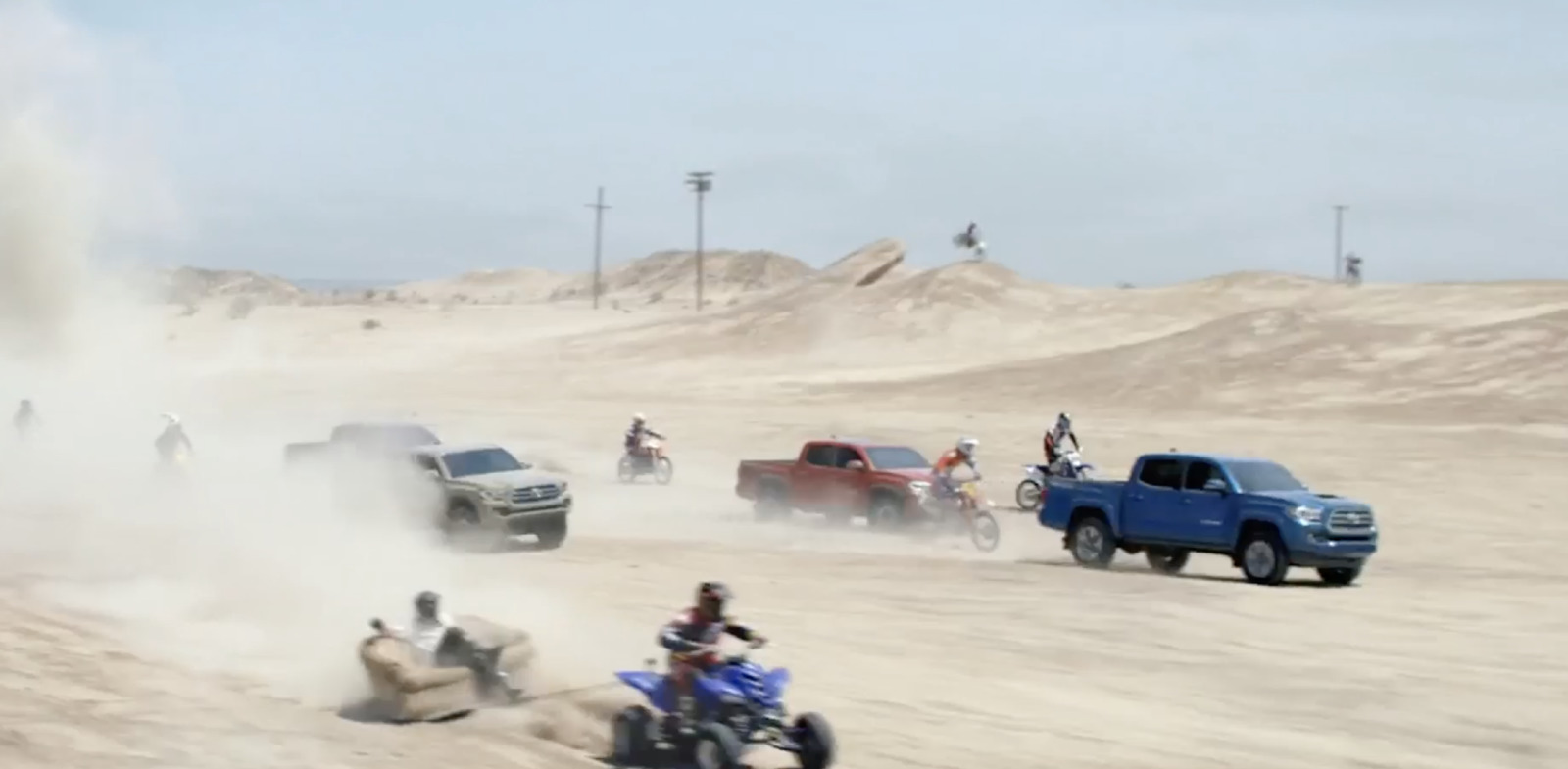 a group of people riding four wheelers in the sand