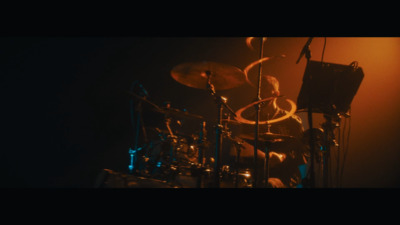 a drummer playing drums in a dark room