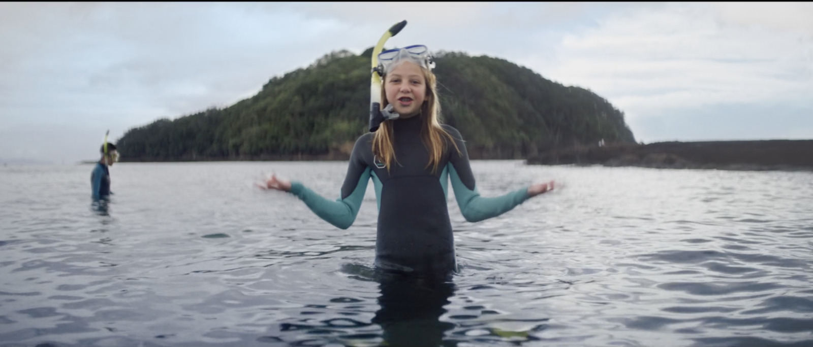 a woman in a wet suit standing in the water