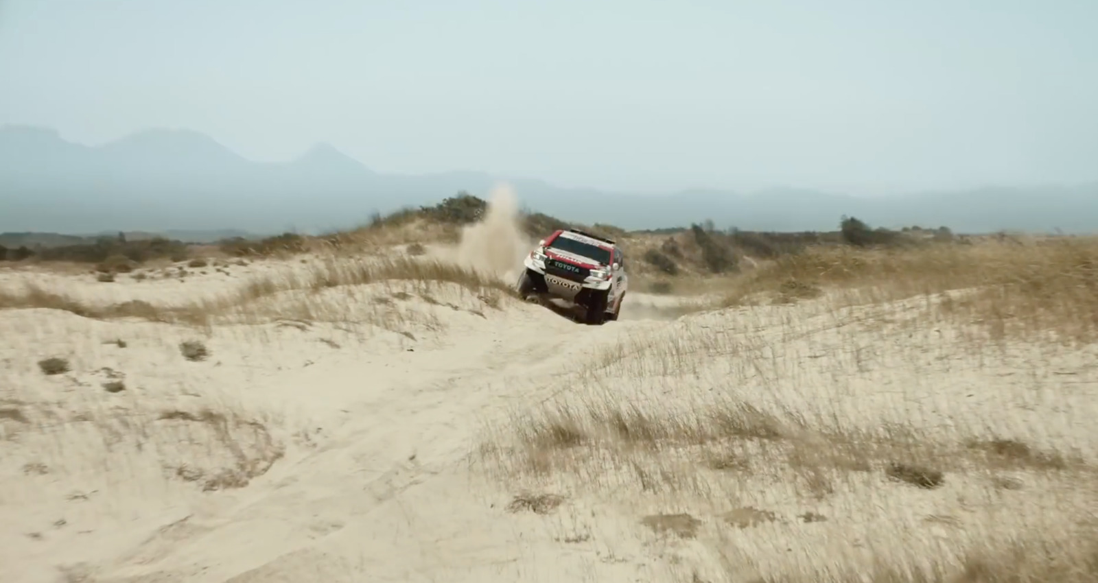 a truck is driving through the sand dunes