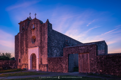 an old church with a cross on the top of it