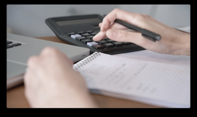 a person using a calculator on a desk