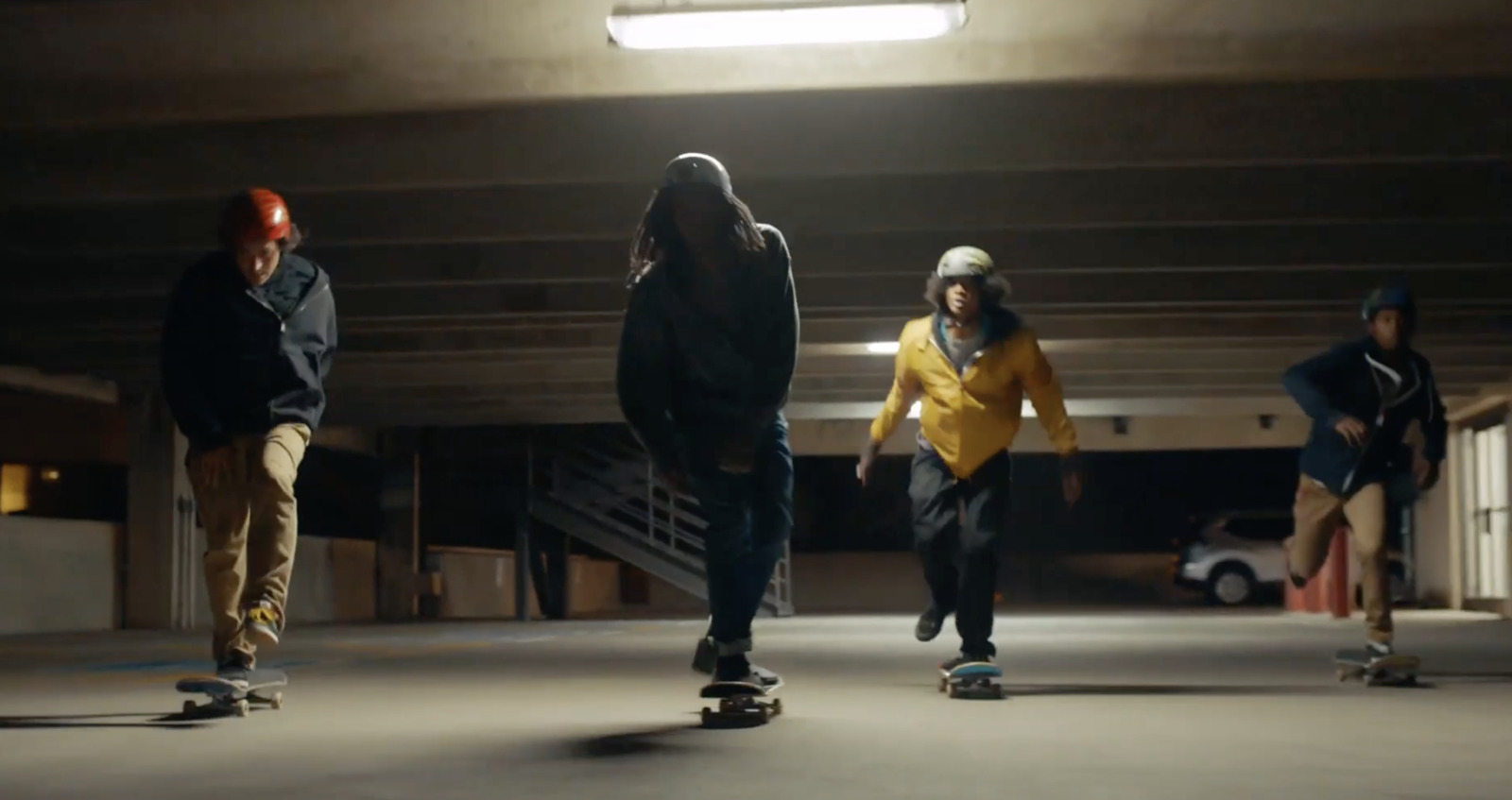 a group of people riding skateboards in a parking garage