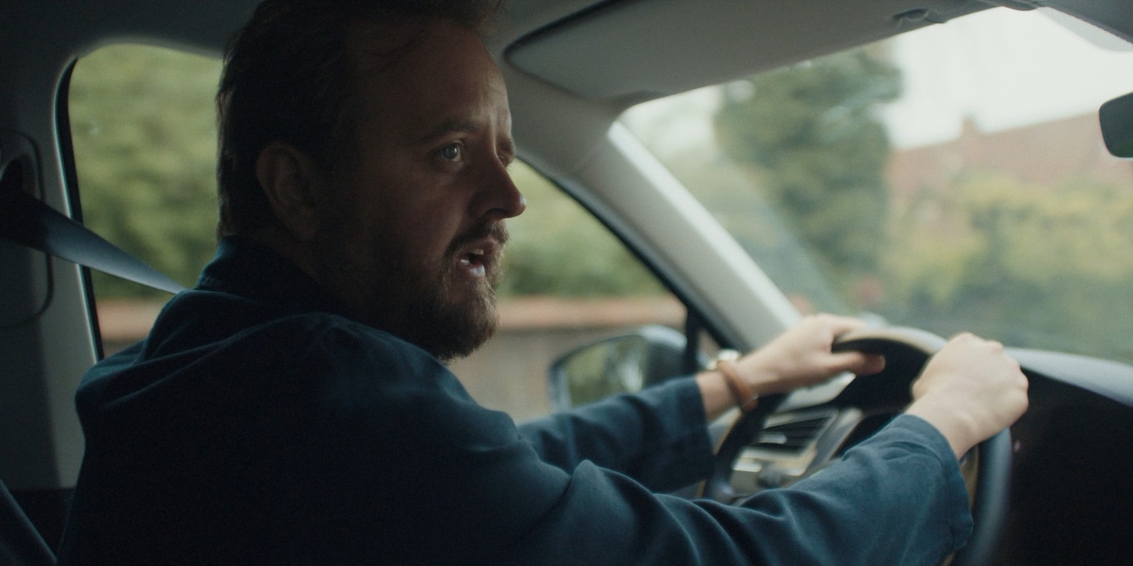 a man driving a car in the rain