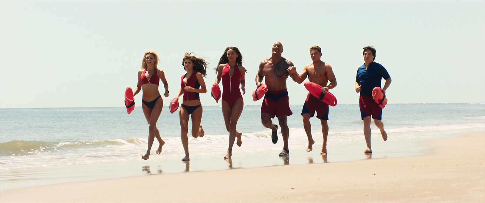 a group of people running on the beach