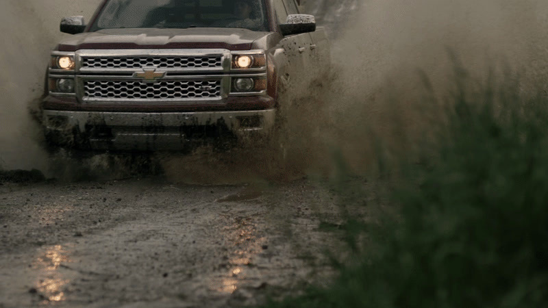 a truck driving through a puddle of mud