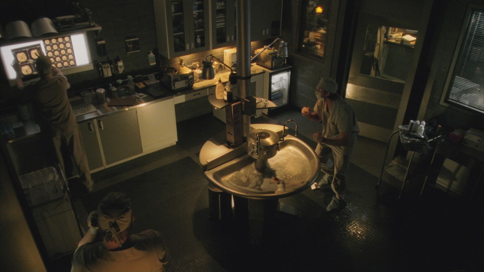 a couple of people in a kitchen with a sink