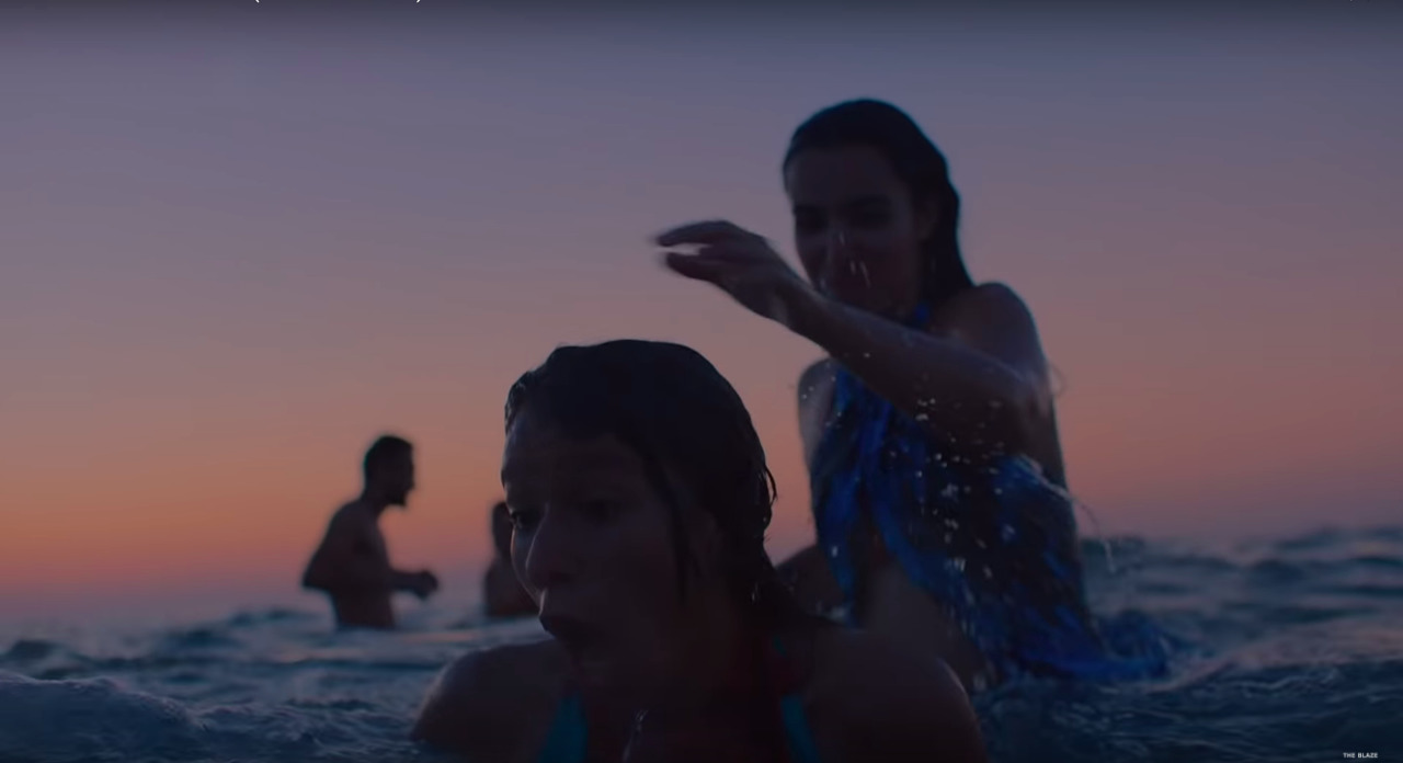 two girls in the ocean at sunset