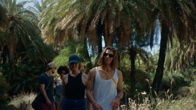 a group of people walking down a dirt road