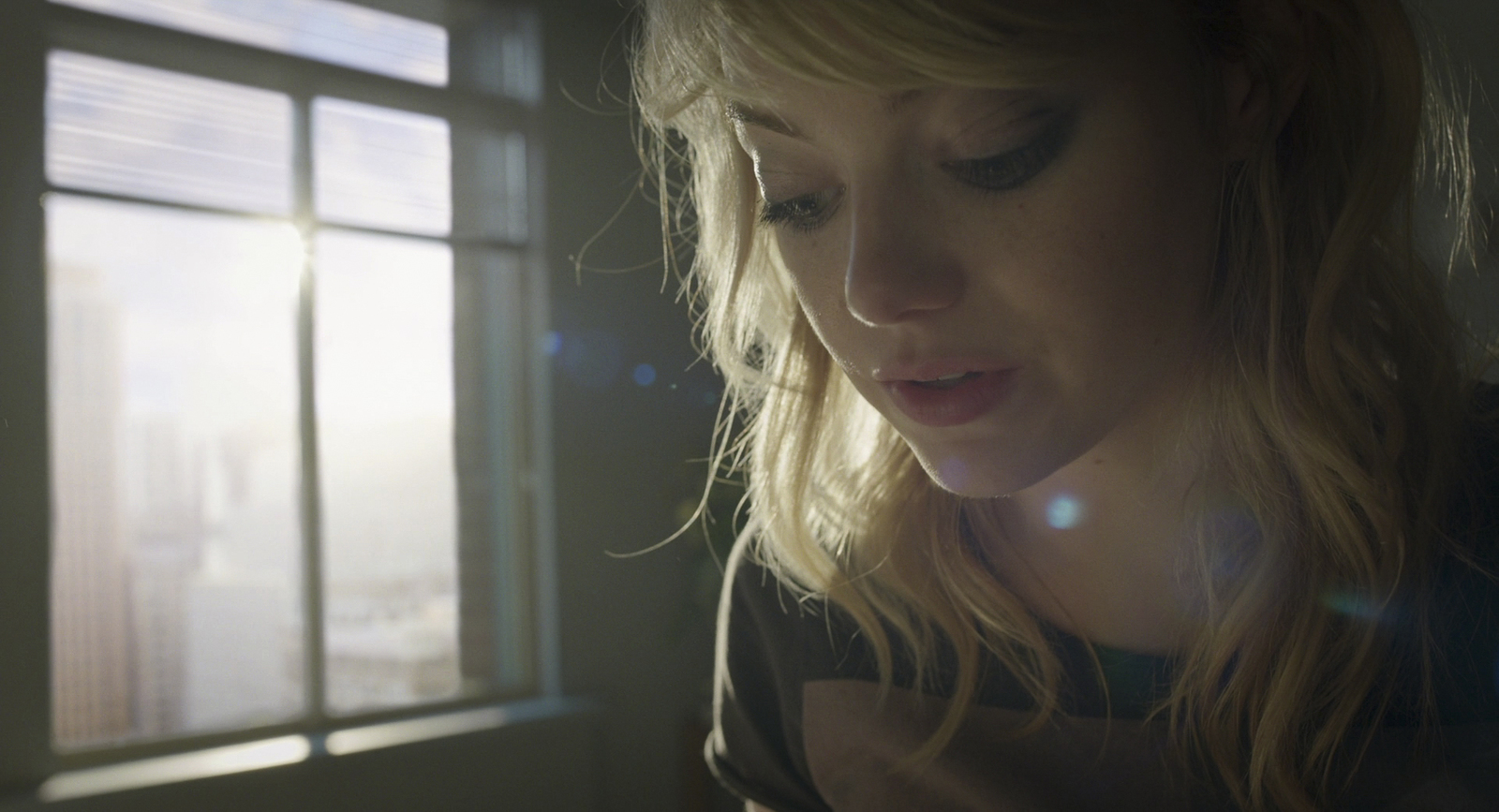 a woman looking at her cell phone in front of a window