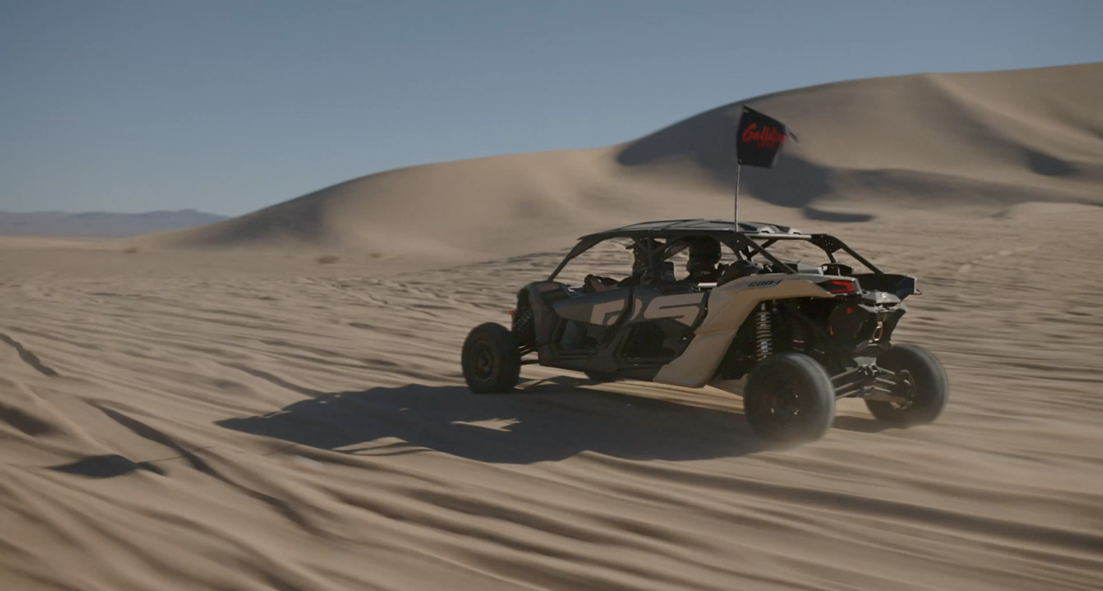 a person riding a dune buggy in the desert