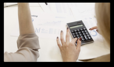 a woman using a calculator on top of a table