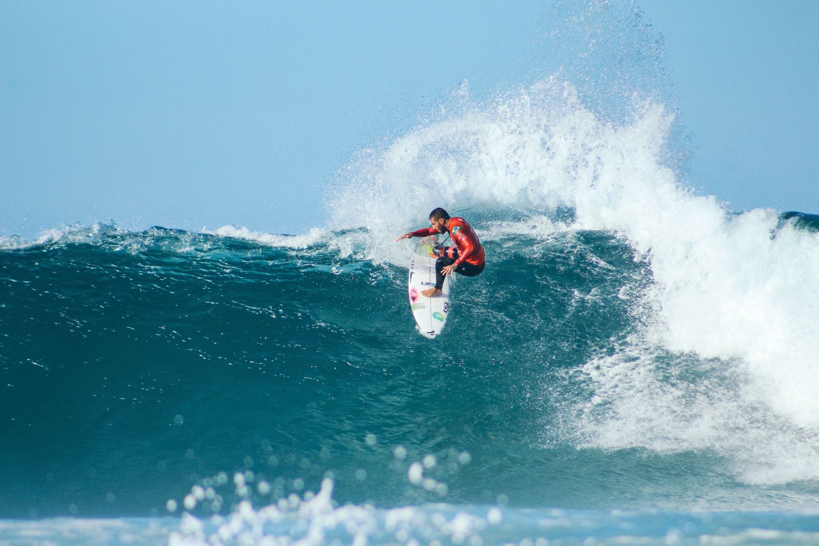 a man riding a wave on top of a surfboard