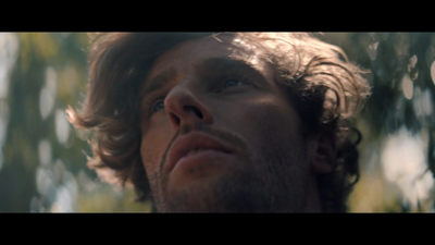 a close up of a person with a tree in the background