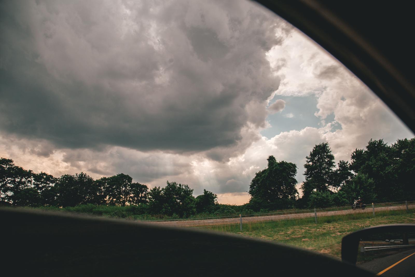 a view of a cloudy sky from a car window