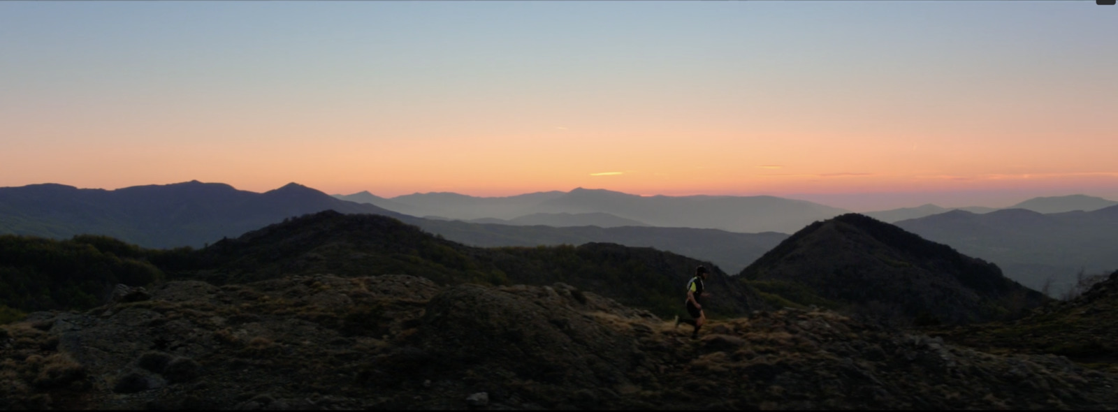 a person standing on top of a mountain at sunset