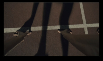 a person standing on a tennis court with their feet in the air