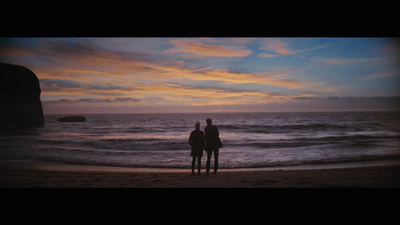 a couple of people standing on top of a beach