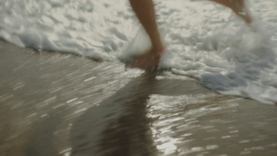 a person walking on a beach next to the ocean