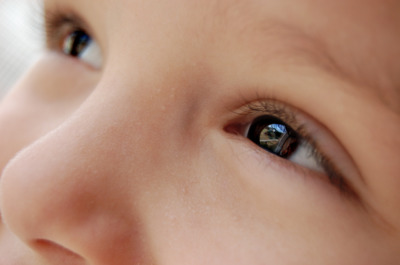 a close up of a child's face with blue eyes