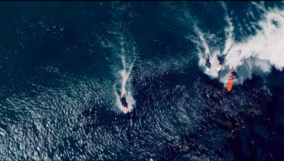 two surfers are riding a large wave in the ocean