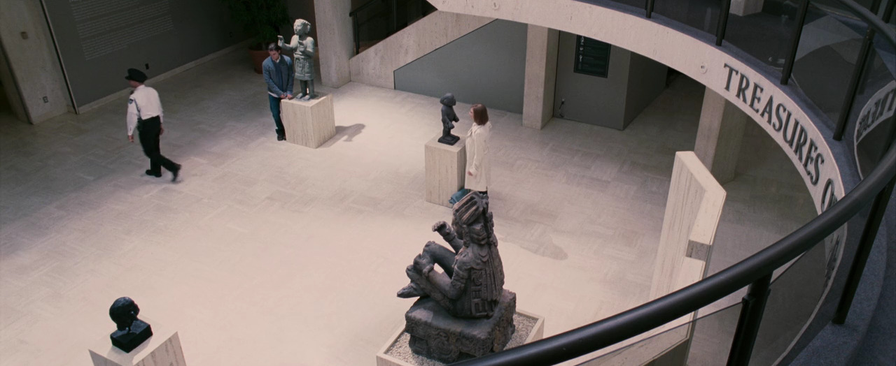 a group of people walking around a museum