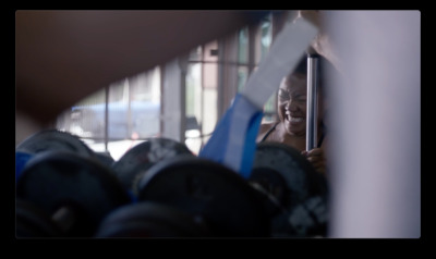 a woman looking through a window at a rack of tennis rackets