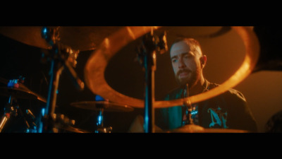 a man playing drums in a dark room