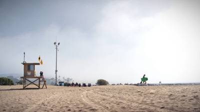 a lifeguard station on the beach with people standing around