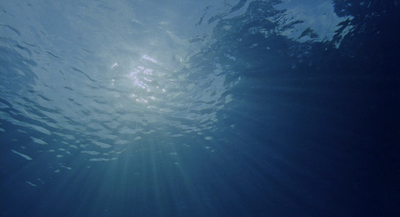 the sun shining through the water on a sunny day