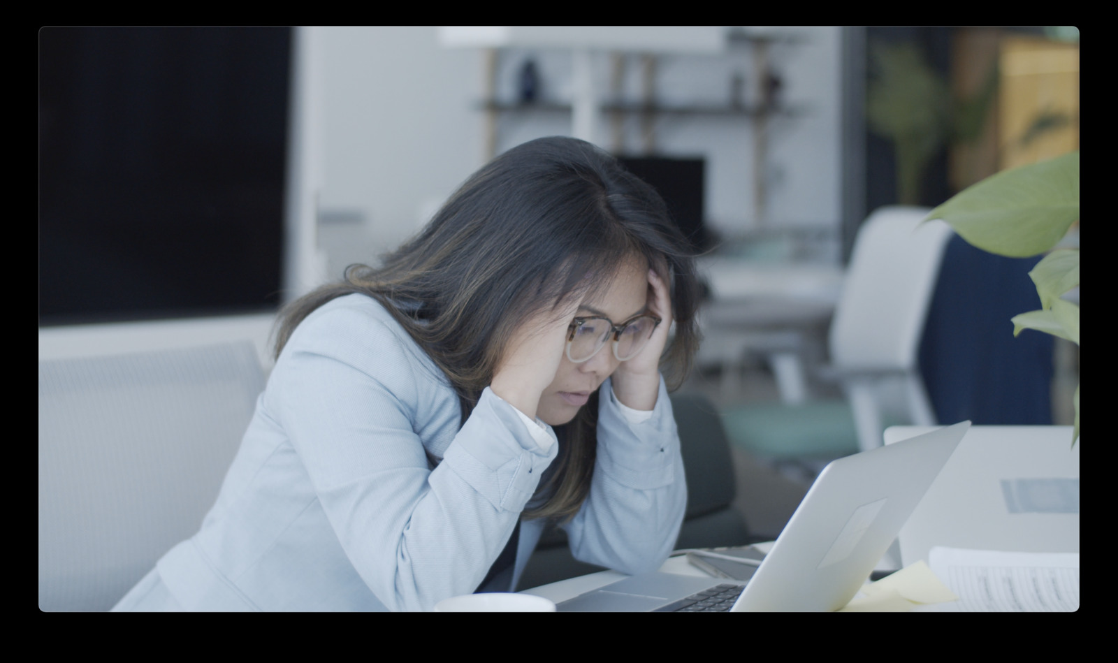 a woman sitting at a desk with a laptop computer