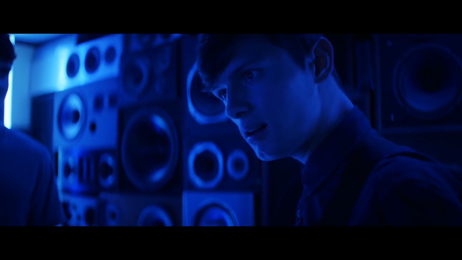 a man standing in front of a wall of speakers