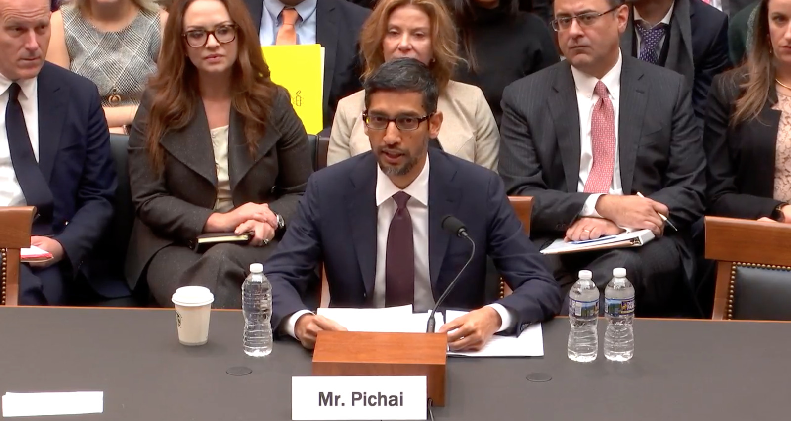 a man sitting at a table in front of a group of people